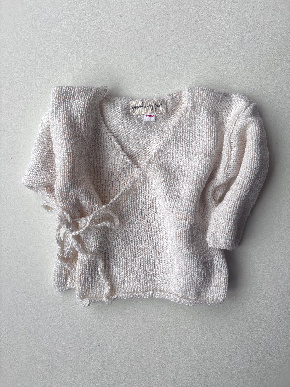 Cream eri silk knitted baby cardigan on a white background
