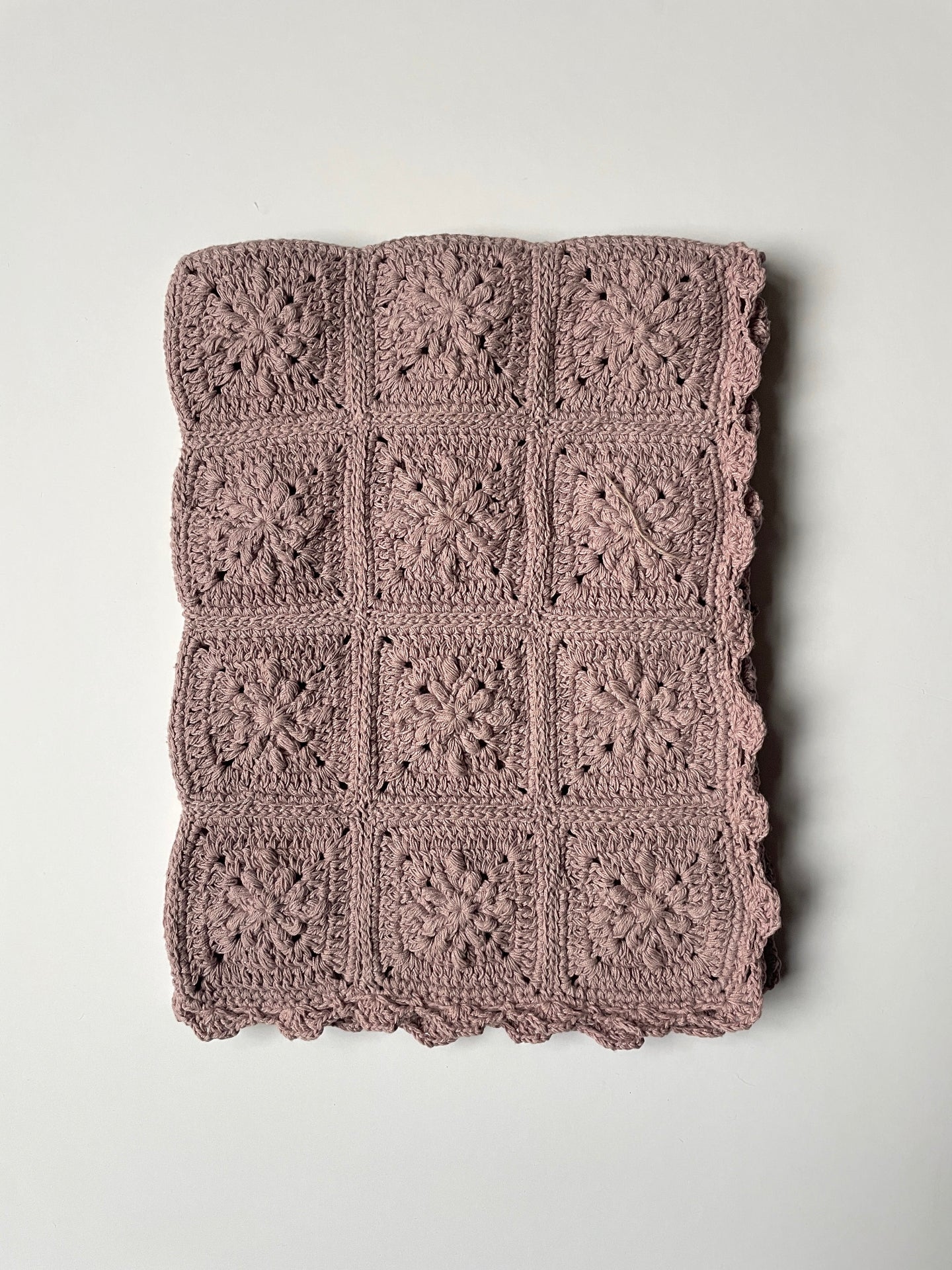image shows chalky pink organic cotton crochet baby blanket