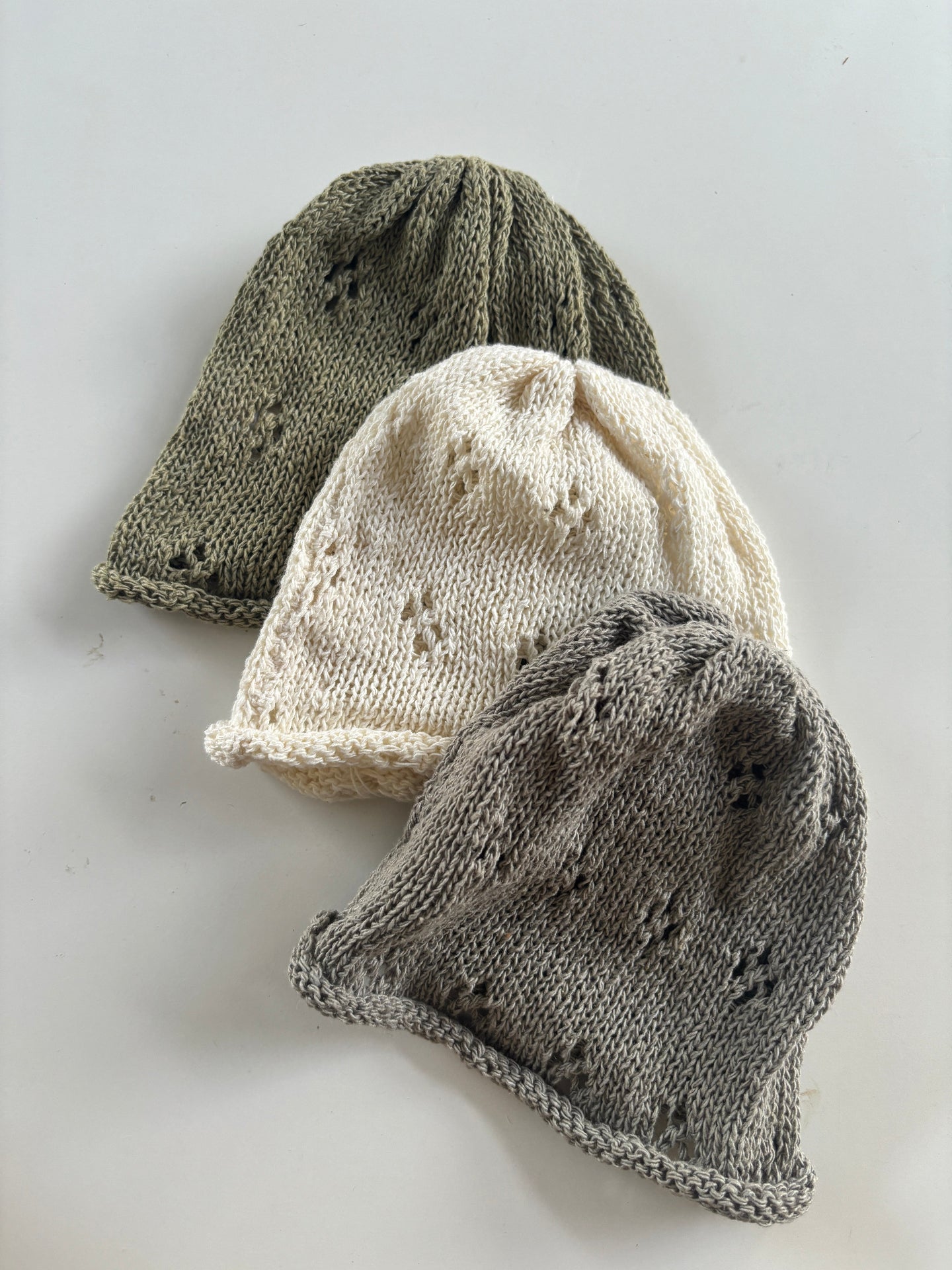 image shows neutral earth tone baby hats